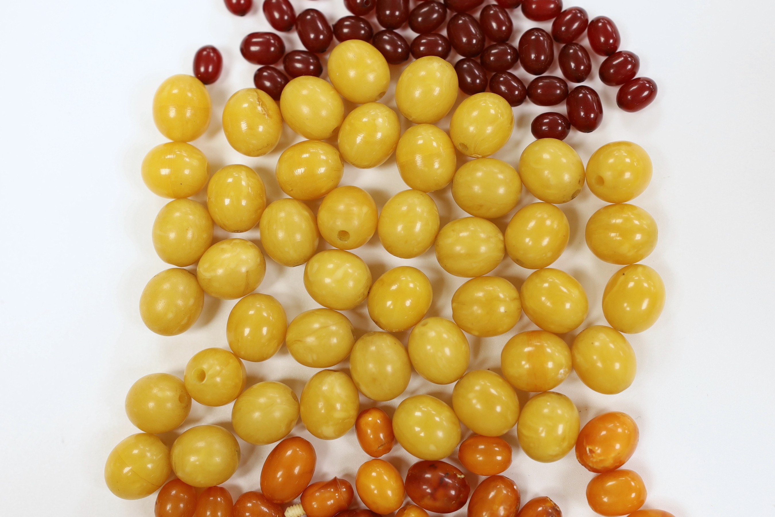 A group of loosed butterscotch amber beads, gross 31 grams, a group of loose yellow amber beads and a group of loose simulated cherry amber beads.